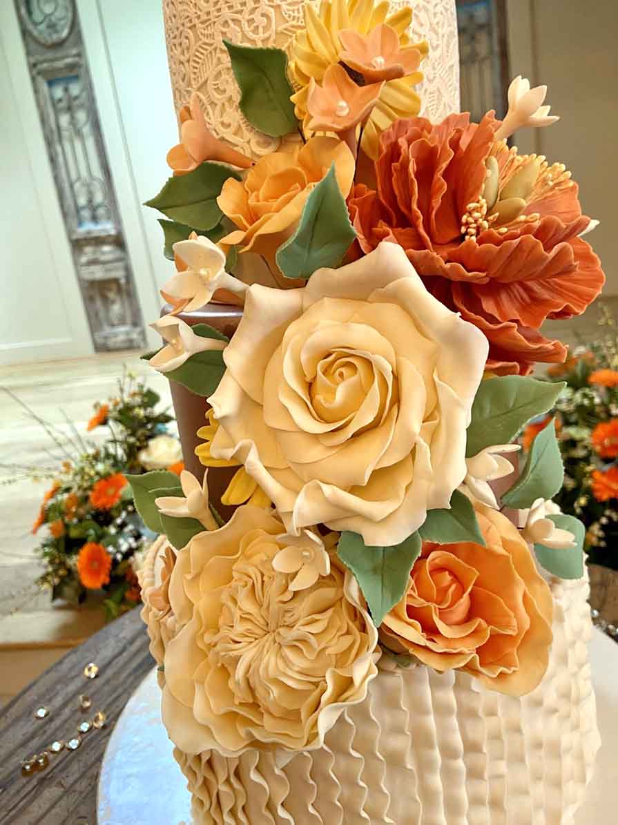 Orange Sugar Flower Decorations On A Wedding Cake