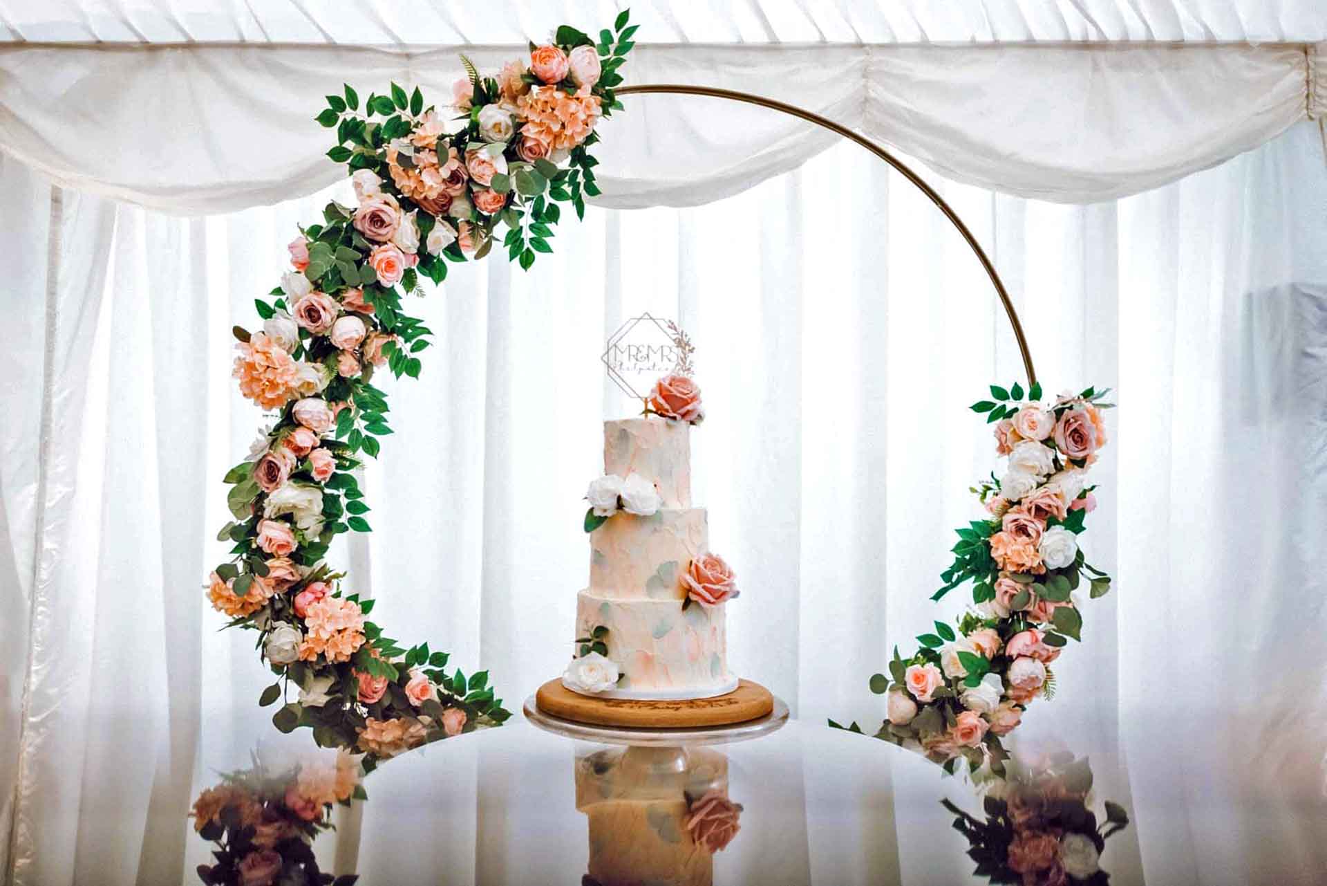 Wedding Cake Under A Rose Arch